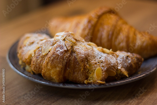 close-up of croissants stacked on wooden table.
