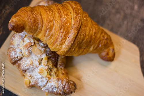 close-up of croissants stacked on wooden table.