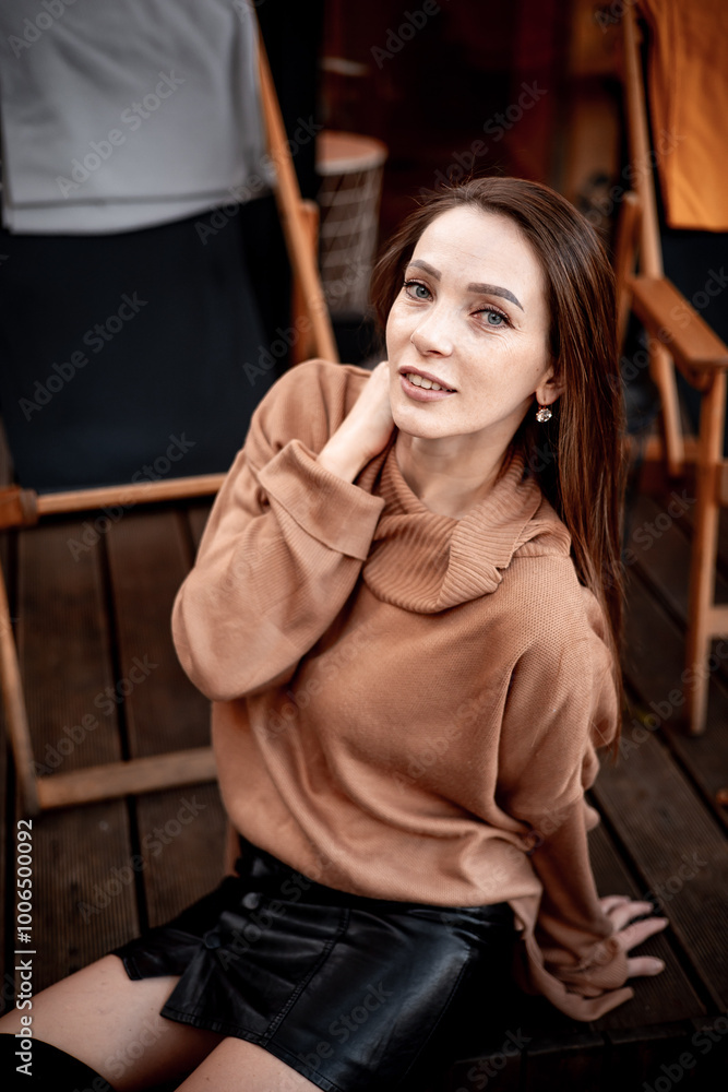 a young girl in autumn in a cafe in brown and orange tones on an outdoor terrace a young girl in autumn in a cafe in brown and orange tones on an outdoor terrace