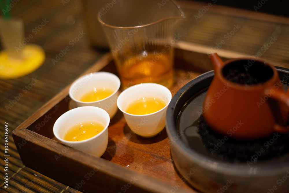 close up cup of Chinese tea and teapot serve on wooden tray close up cup of Chinese tea and teapot serve on wooden tray