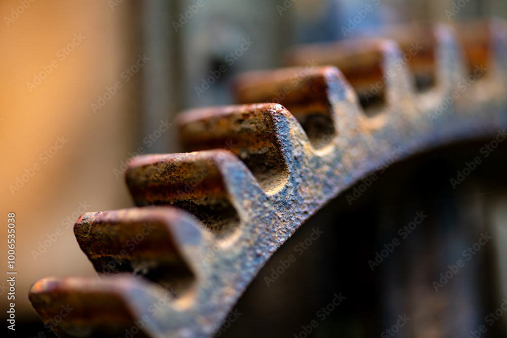 Rusty old cast iron gear wheel with corroded and weathered surface. Macro shot of a colorful steel component of a historical machine with selective focus. Symbol for power transmission and work. Rusty old cast iron gear wheel with corroded and weathered surface. Macro shot of a colorful steel component of a historical machine with selective focus. Symbol for power transmission and work.