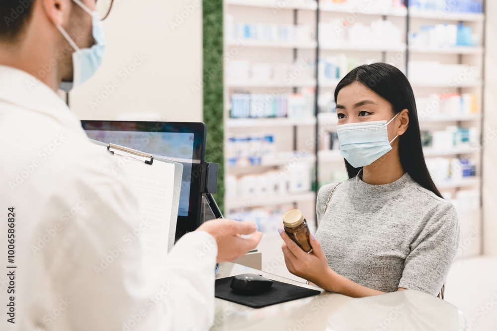 Male pharmacist druggist in protective face mask against coronavirus advising female customer client buyer remedy, medicines, pills, antibiotics against Covid19 in pharmacy Male pharmacist druggist in protective face mask against coronavirus advising female customer client buyer remedy, medicines, pills, antibiotics against Covid19 in pharmacy