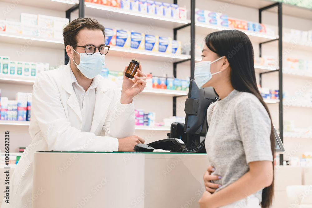 Male caucasian pharmacist druggist in medical face mask against Covid19 advising showing remedy, pills, medicines, drugs to a female customer client suffering from stomach ache diarrhea Male caucasian pharmacist druggist in medical face mask against Covid19 advising showing remedy, pills, medicines, drugs to a female customer client suffering from stomach ache diarrhea