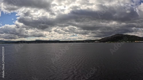 Alta Municipality, Finnmark, Norway - timelapse view from cruise ship balcony onto town located on the southern end of Altafjorden by river Altaelva on cloudy day photo