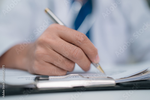 Dedicated Doctor in Hospital Providing Health Care. Using a Pen to Document Patient Signs Approve Medical Agreements, Ensuring Comprehensive Consultation and Insurance Coverage for Optimal Treatment