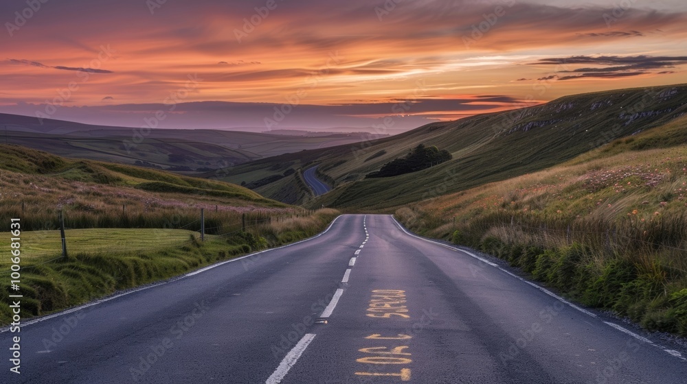 Fototapeta premium Winding Road Through Hills at Sunset: Beautiful Vistas and Calm Scenery