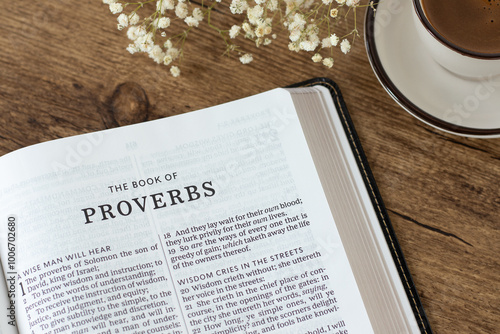 Proverbs open holy bible book with coffee cup on wooden desk. Studying and reading old testament Scripture, wisdom from God Jesus Christ, Christian biblical concept.