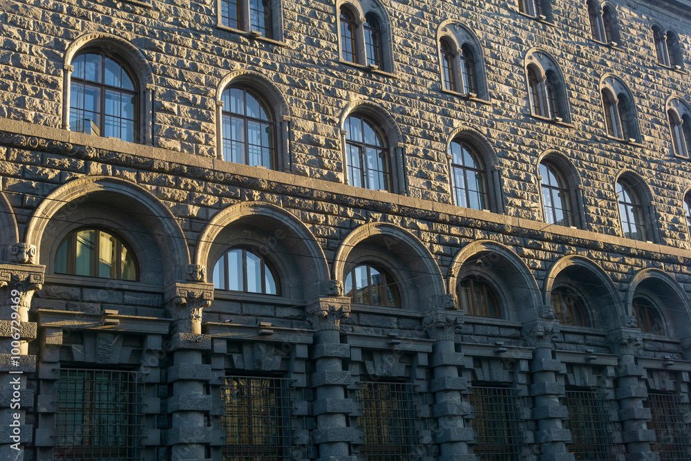 Obraz premium architectural background, dark facade of an old city building, barely illuminated by the morning sun rays