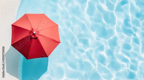 A red umbrella is sitting on the edge of a pool
