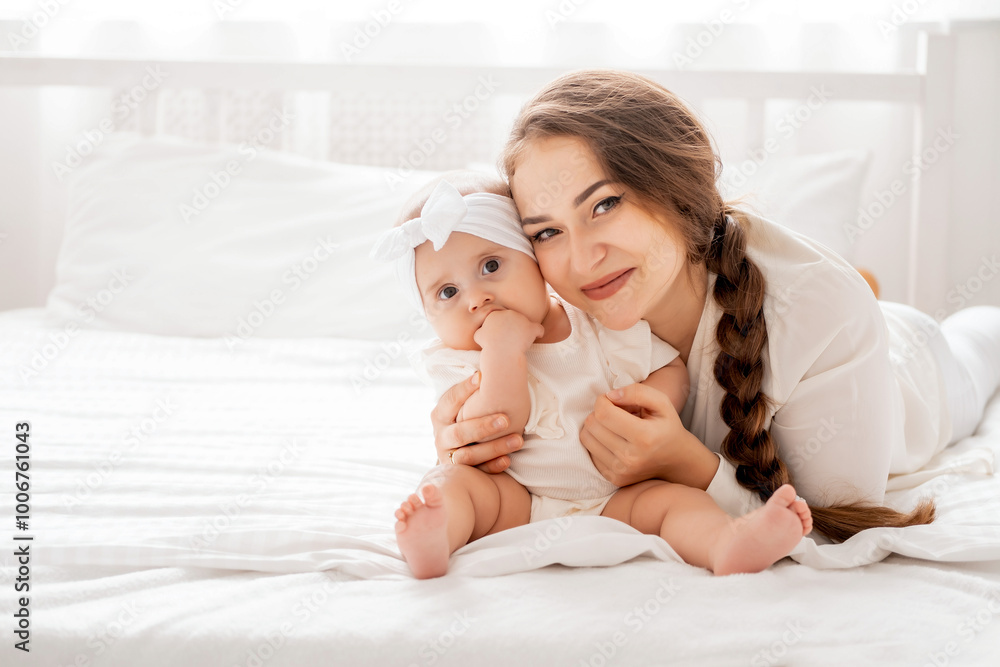 mom and baby are playing and rejoicing in a bright white room on mom and baby are playing and rejoicing in a bright white room on