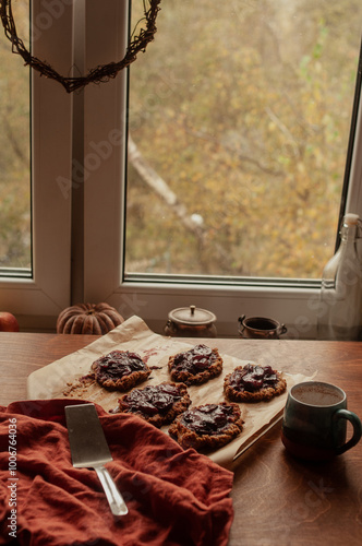 Home made seasonal plum pies or tarts with oatmeal crust aesthetic seasonal  moodyy lifestyle autumn usg shot with pumpkin decoration back light