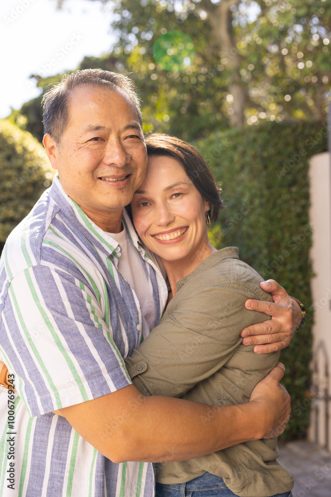 Smiling couple embracing outdoors, enjoying quality time together in garden Smiling couple embracing outdoors, enjoying quality time together in garden
