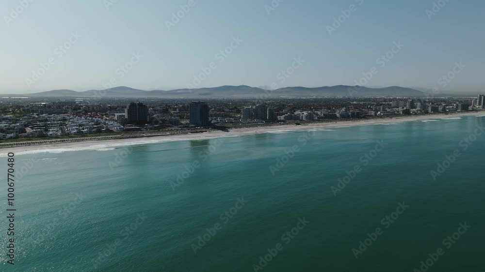 Drone clip over calm ocean showing a very built up coastal city and long stretch of beach Drone clip over calm ocean showing a very built up coastal city and long stretch of beach