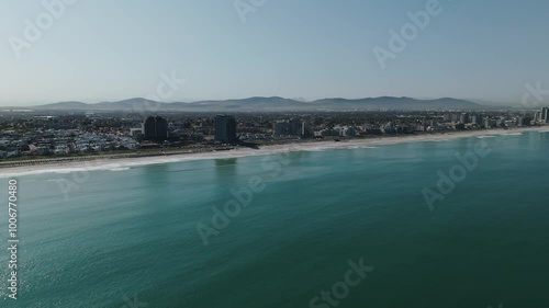 Wallpaper Mural Drone clip over calm ocean showing a very built up coastal city and long stretch of beach Torontodigital.ca