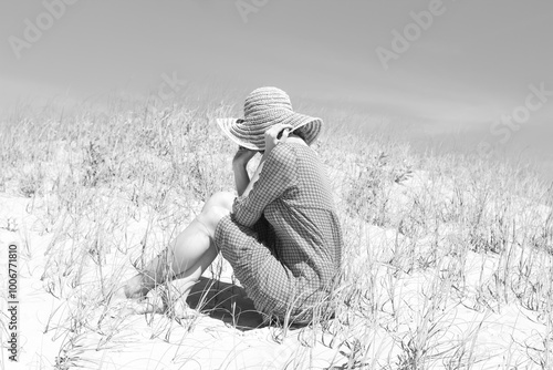 woman with short hair and sun hat on top of dunes photo