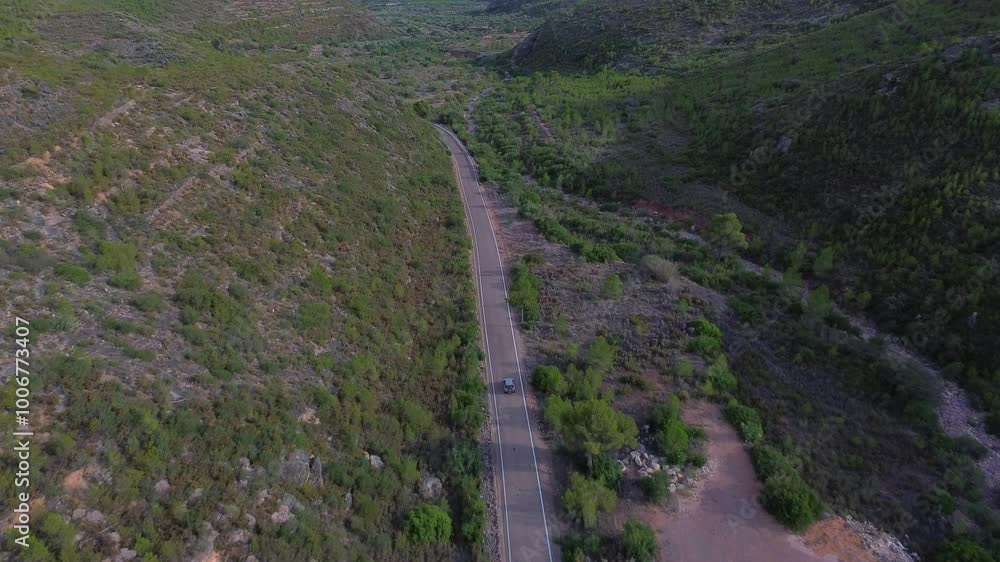 Follow up aerial shot of a tourist car driving through a road on mountainous regioins of Altura, Comunidad Valenciana, Spain. Follow up aerial shot of a tourist car driving through a road on mountainous regioins of Altura, Comunidad Valenciana, Spain.