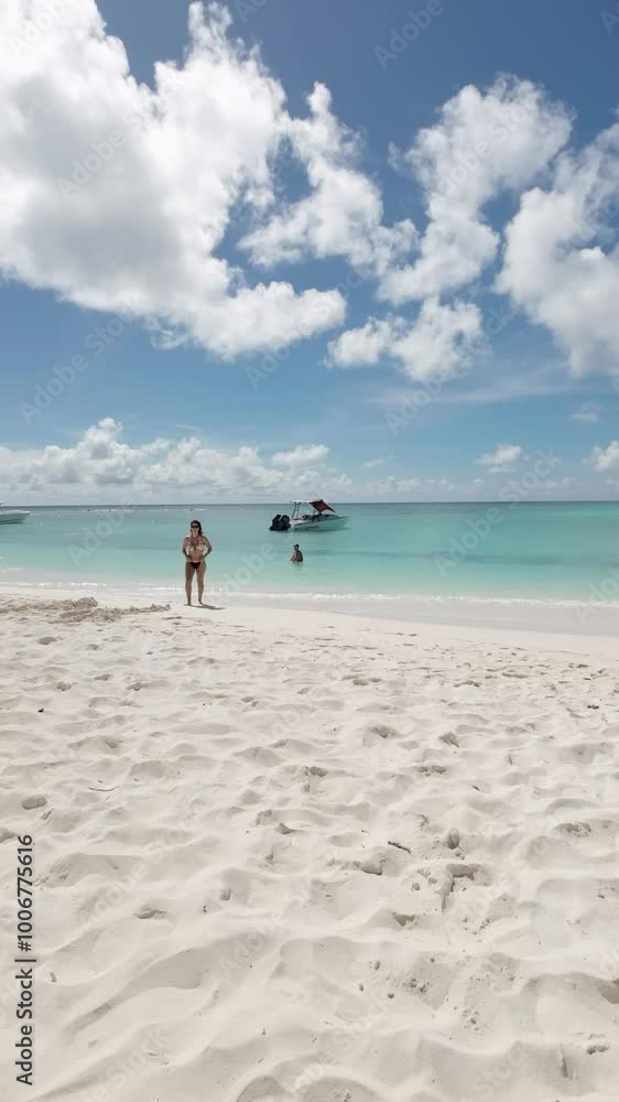 Hispanic Young beautiful woman straightens her hair while stand on white sand beach, Los Roques Hispanic Young beautiful woman straightens her hair while stand on white sand beach, Los Roques