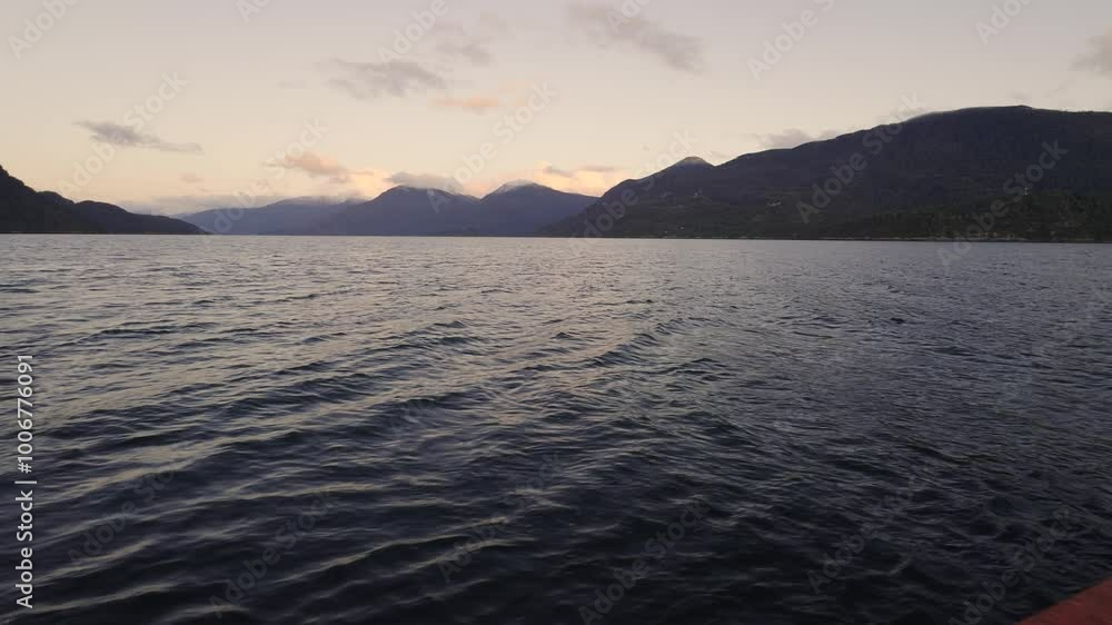 Handheld shot from the deck of a ferry in Chilean Patagonia with sunset light