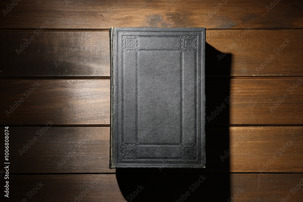 Fotografie Closed Bible on wooden table, top view