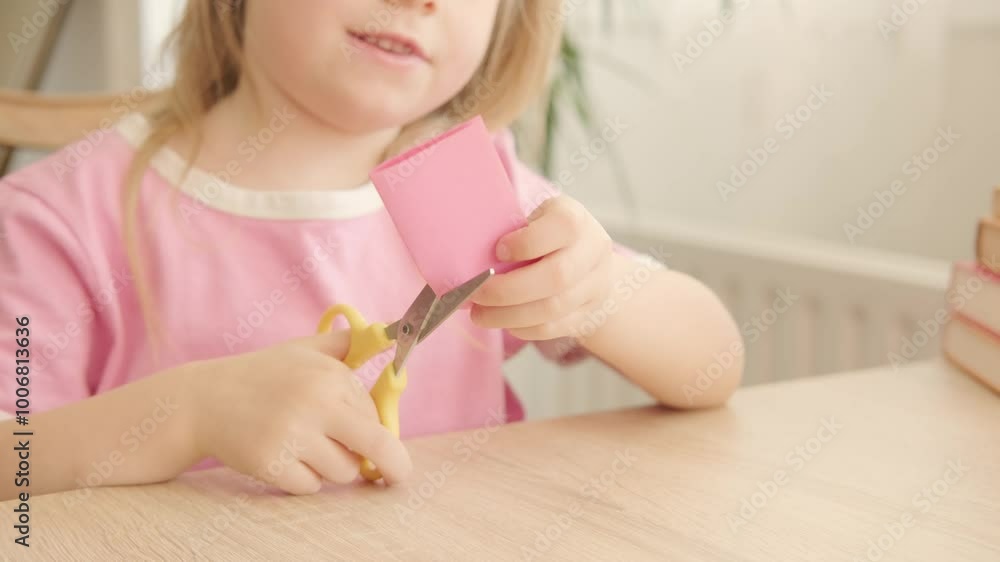young girl learning to cut paper with scissors, making shapes like heart, symbol of love and support for DIY art project, Early childhood development, Artistic expression young girl learning to cut paper with scissors, making shapes like heart, symbol of love and support for DIY art project, Early childhood development, Artistic expression