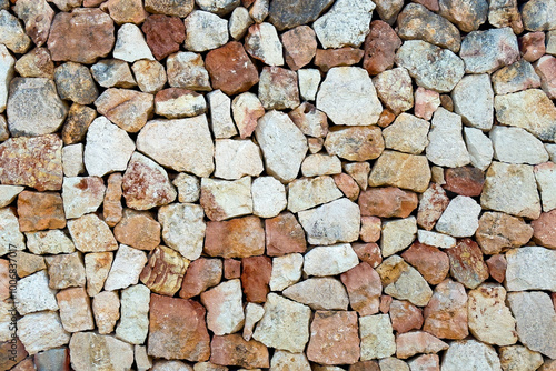 Textured old stone block wall. Front view. Abstract brown rock background