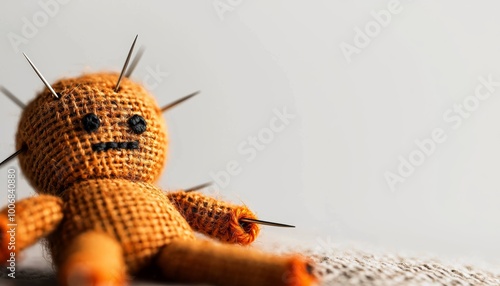 A creepy voodoo doll with pins stuck in various places, isolated against a white background
