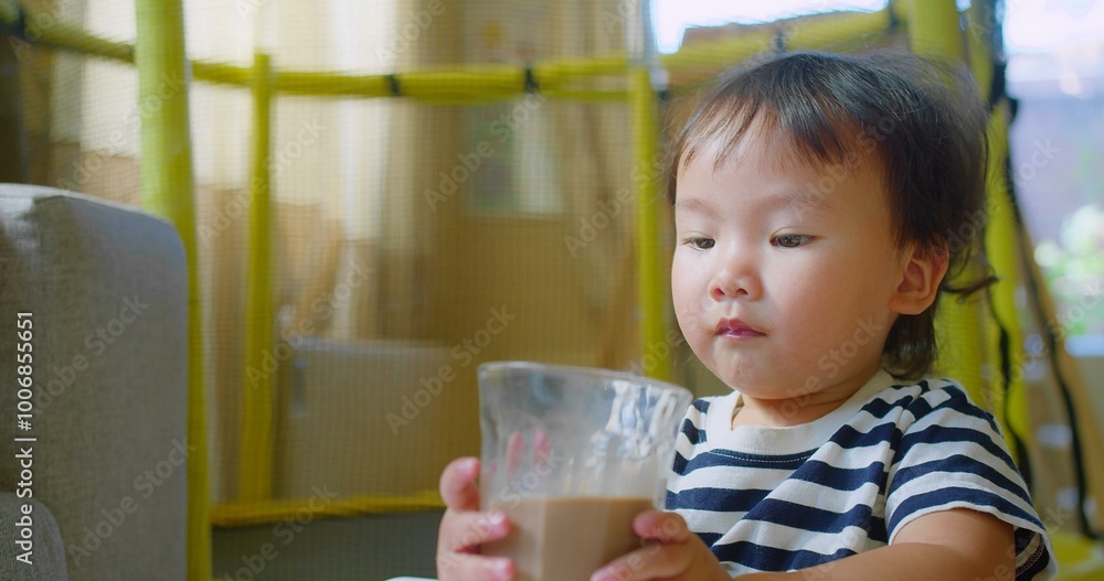 Adorable Cute Toddler child enjoying Drinking Chocolate Milk from a glass sitting in a cozy home, Capturing a Sweet and Innocent Moment of Childhood Adorable Cute Toddler child enjoying Drinking Chocolate Milk from a glass sitting in a cozy home, Capturing a Sweet and Innocent Moment of Childhood