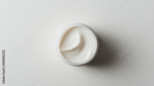 Close-up top view of a moisturizing cream sample with a smooth, shiny surface. No branding or logo. Presented on a clean white background.