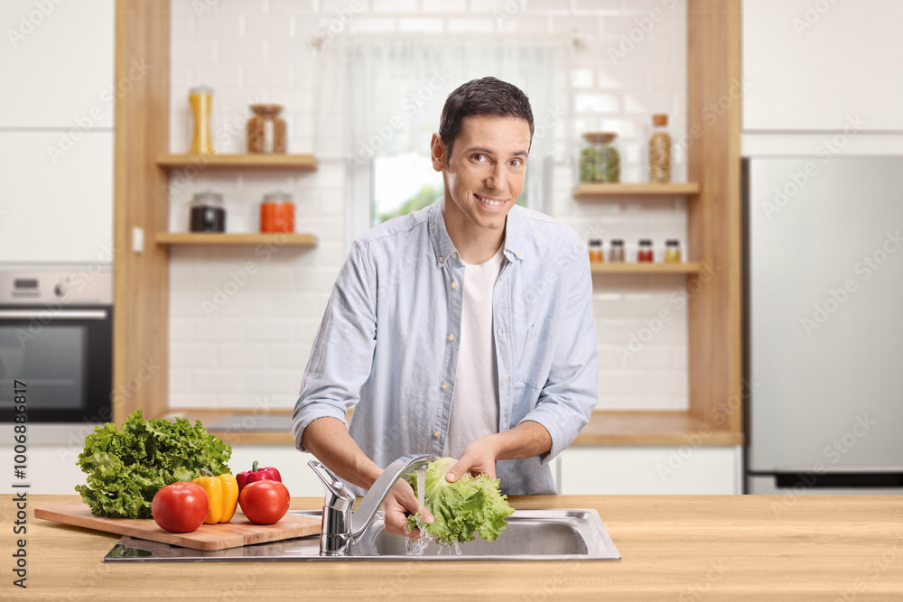 © Ljupco Smokovski - Young man washing vegetables in a kitchen sink