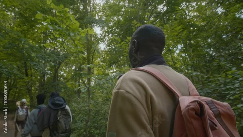 Wallpaper Mural Handheld shot of multiethnic group of people walking on green forest trail while on hiking trip in summertime Torontodigital.ca