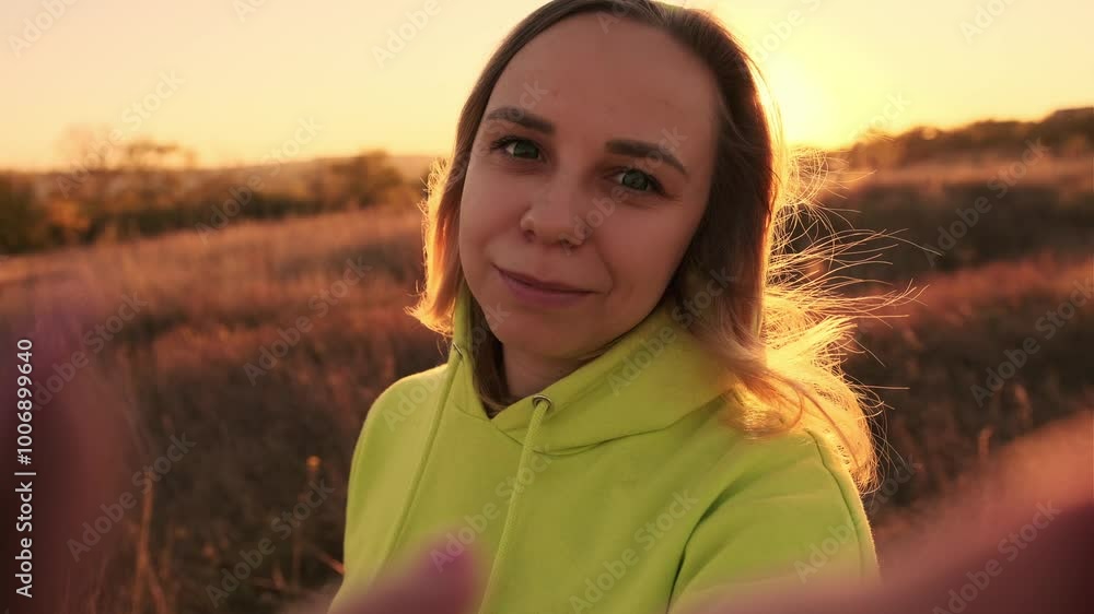 A woman captures a joyful selfie during golden hour in a serene outdoor setting, surrounded by nature and warm sunlight A woman captures a joyful selfie during golden hour in a serene outdoor setting, surrounded by nature and warm sunlight