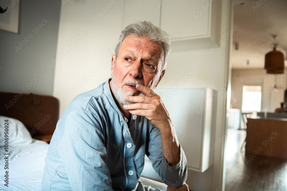Worried senior Caucasian man sitting alone at home, deep in thought Worried senior Caucasian man sitting alone at home, deep in thought