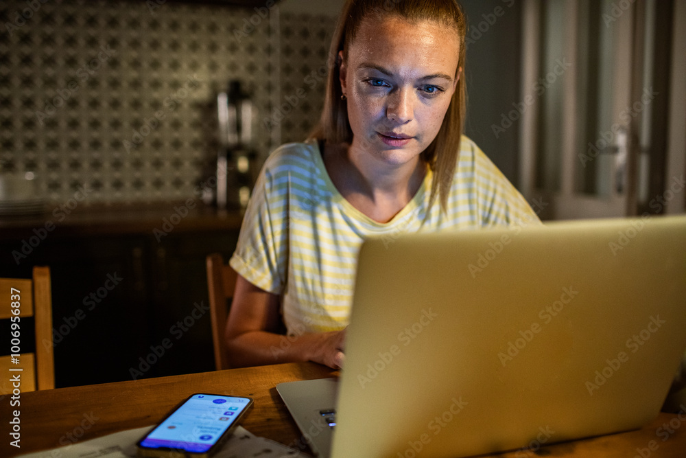 Woman stressed while working on laptop late at night Woman stressed while working on laptop late at night