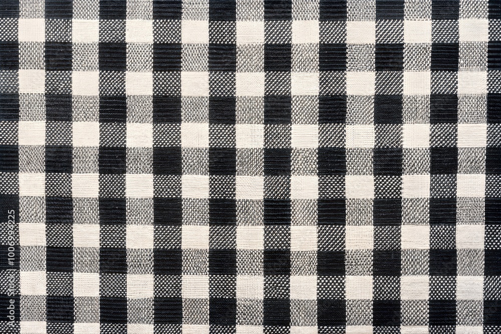 Black and white checkered fabric draping over a surface with soft folds creating a textured appearance. Generative AI Black and white checkered fabric draping over a surface with soft folds creating a textured appearance. Generative AI