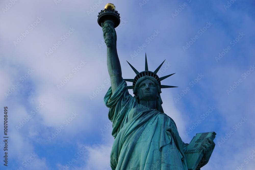 Fototapeta premium Frontales Close Up Portrait vom mit einer Krone besetzten Kopf der Freiheitsstatue in New York, die vor klarem blauen Himmel die Fackel der Freiheit hochhält 