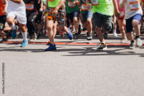 Children marathon runners crowd, young teen sportsmen participants start running in the city streets, crowd of kids joggers in motion, kid group athletes outdoor run, family competition in summer day