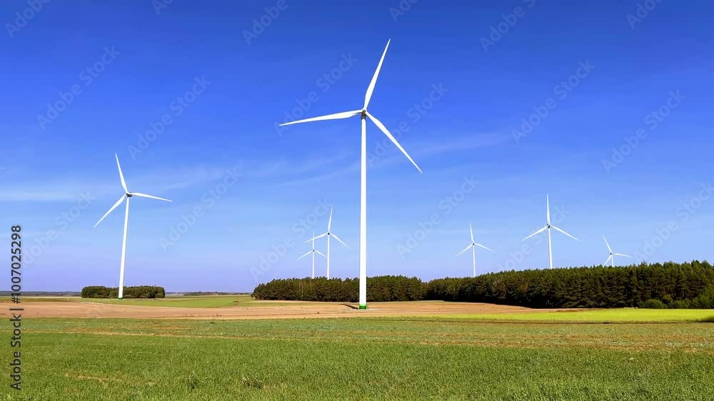 A wind turbine rises in a sun-drenched field, surrounded by trees and nature. The rotating blades represent renewable energy and a commitment to sustainability. A wind turbine rises in a sun-drenched field, surrounded by trees and nature. The rotating blades represent renewable energy and a commitment to sustainability.