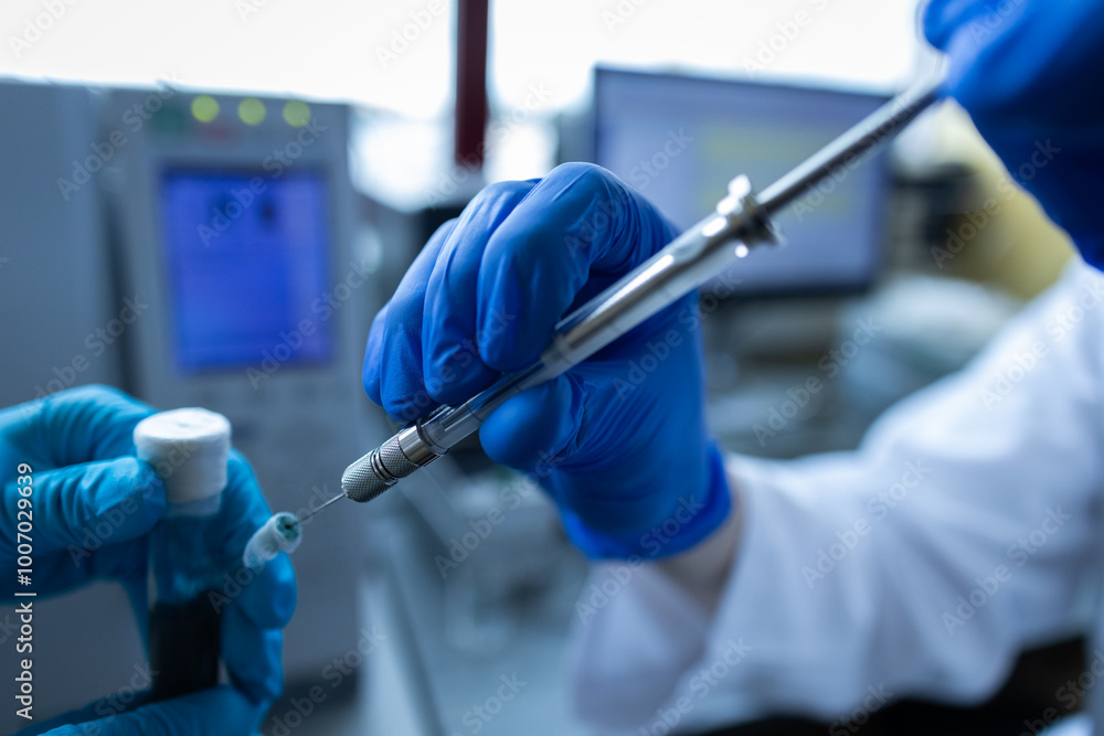 Scientist injecting a sample via the autosampler of HPLC system. High performance liquid chromatography at chemical laboratory. Developing of pharmaceuticals or vaccine. Biochemistry analysis Scientist injecting a sample via the autosampler of HPLC system. High performance liquid chromatography at chemical laboratory. Developing of pharmaceuticals or vaccine. Biochemistry analysis