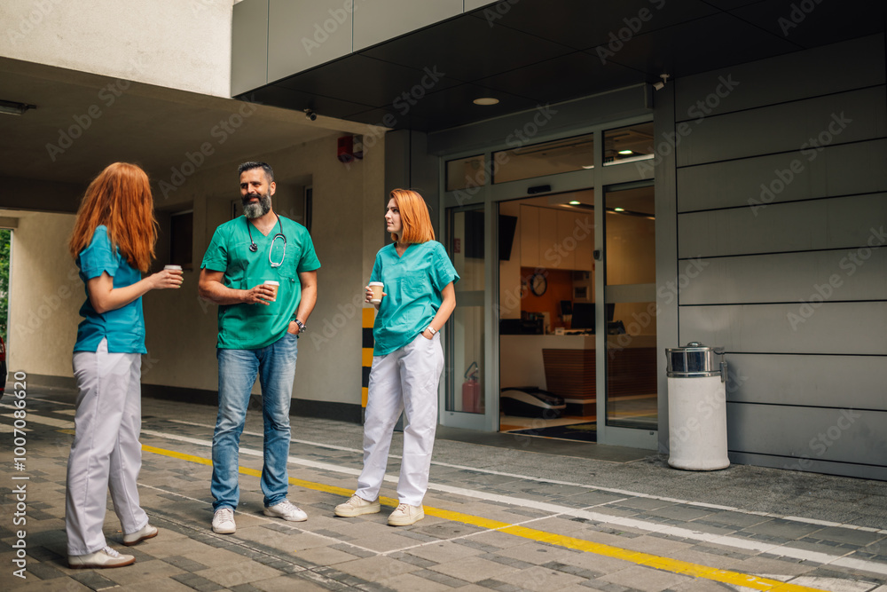 Healthcare professionals enjoying a coffee break, bonding outside facility. Healthcare professionals enjoying a coffee break, bonding outside facility.