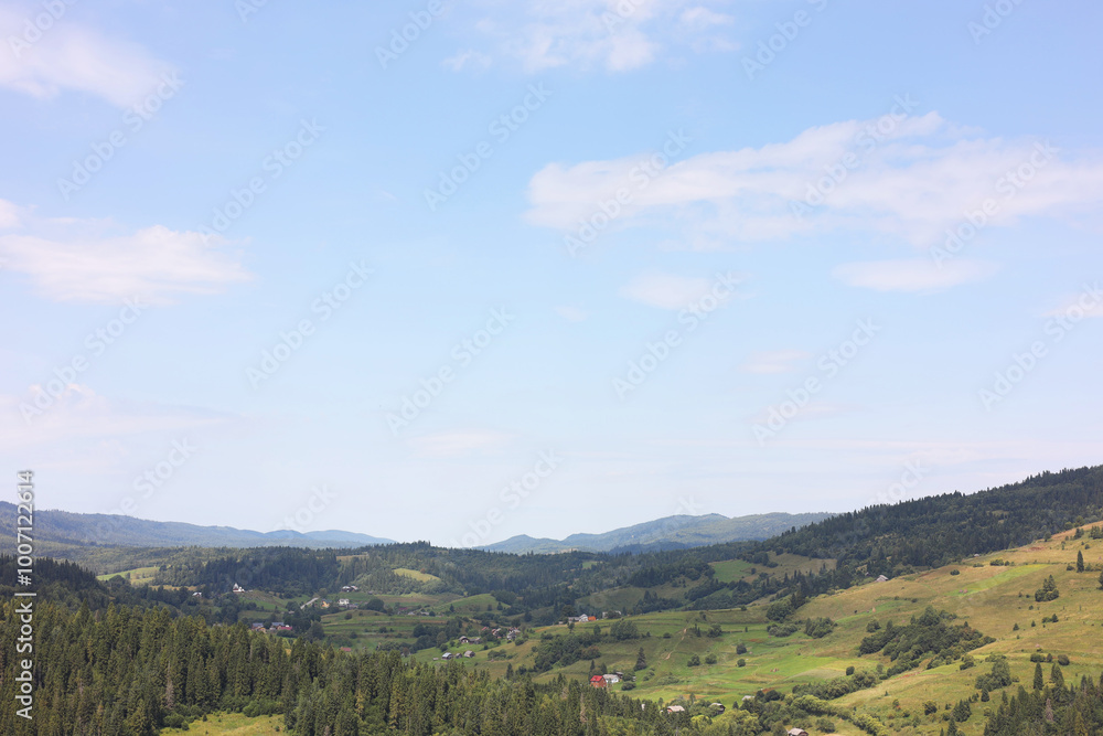 Naklejka premium Picturesque view of forest in mountains under blue sky