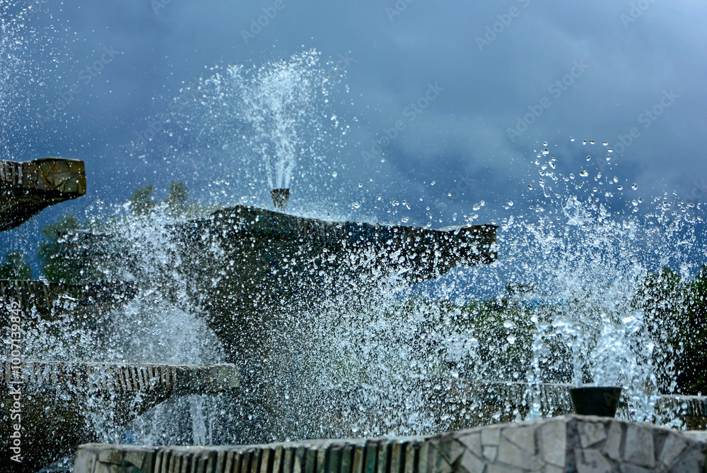miejskie fontanny na tle burzowego nieba, tryskająca woda z miejskich fontann, city fountains against a stormy sky, water gushing from city fountains