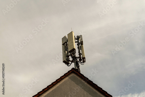 Mobile phone antenna on a house in the fog photo