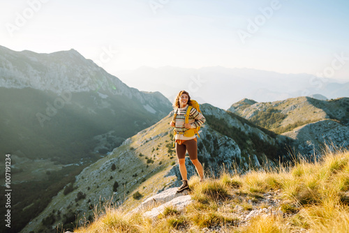 Quadro su tela Woman tourist standing at mountains with backpack admiring landscape
