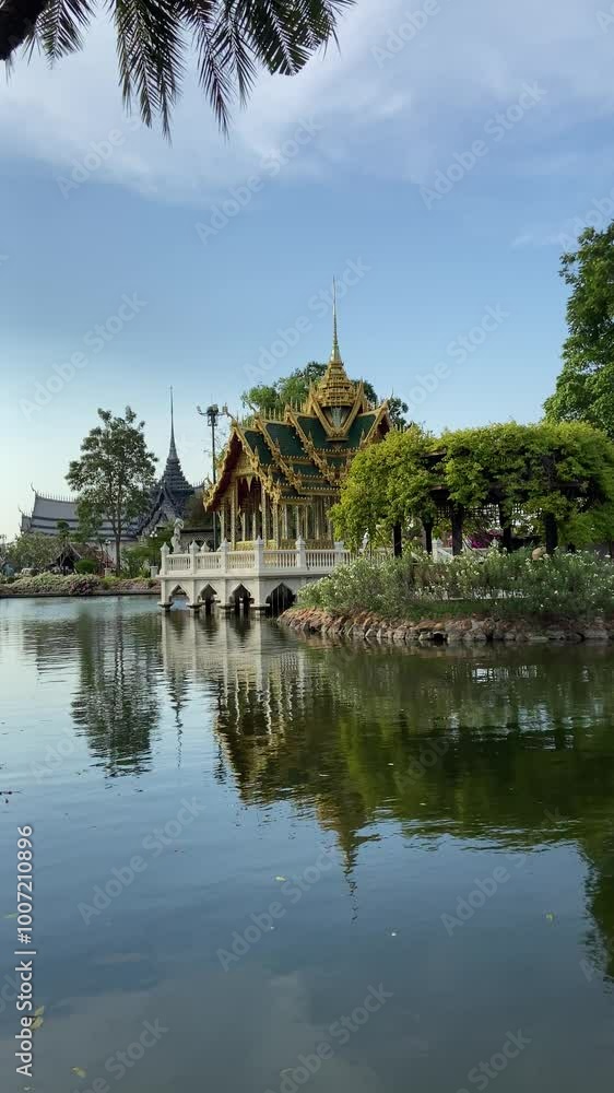The Asian temple and tropical flowers near the lake in Ancient Siam The Asian temple and tropical flowers near the lake in Ancient Siam