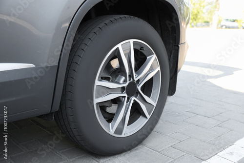 Modern grey car parked on paved road, closeup