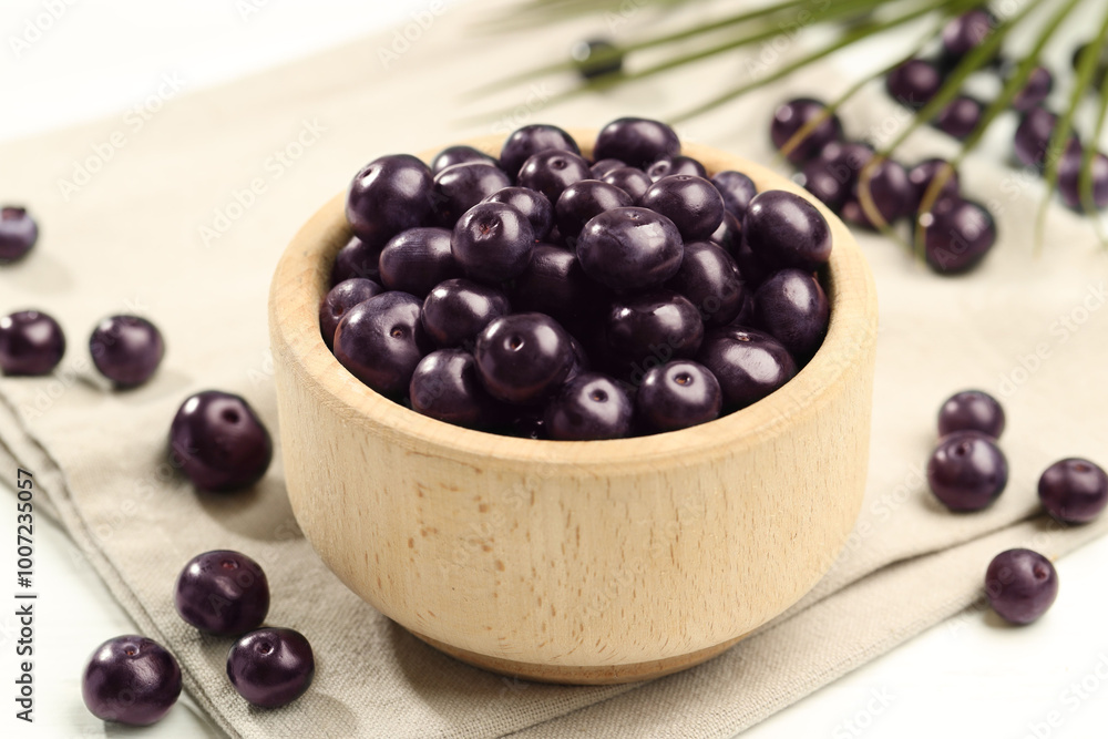 Ripe acai berries in bowl on light table, closeup Ripe acai berries in bowl on light table, closeup