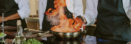 Header of unrecognizable sous chef cooking flambe steak in professional kitchen