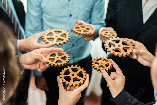 Group of multiracial business people joining gear wheels together as effective unity and productive teamwork concept. Efficient system business team process for solution solving. Meticulous
