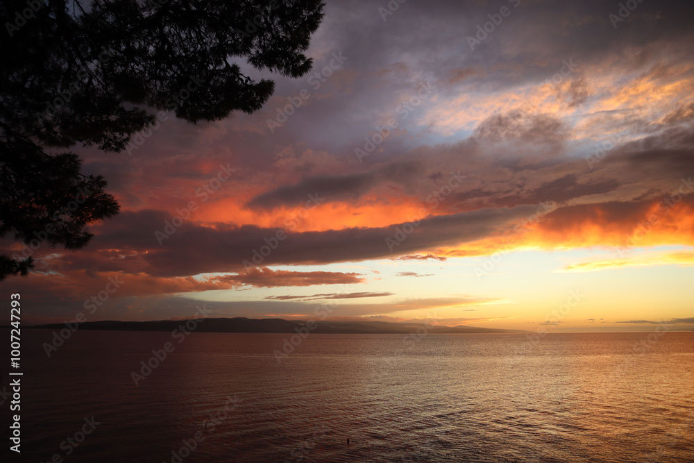 Picturesque sky with clouds at sunset on the Croatian coast. Clouds and sea in the rays of the setting sun on an autumn evening Picturesque sky with clouds at sunset on the Croatian coast. Clouds and sea in the rays of the setting sun on an autumn evening
