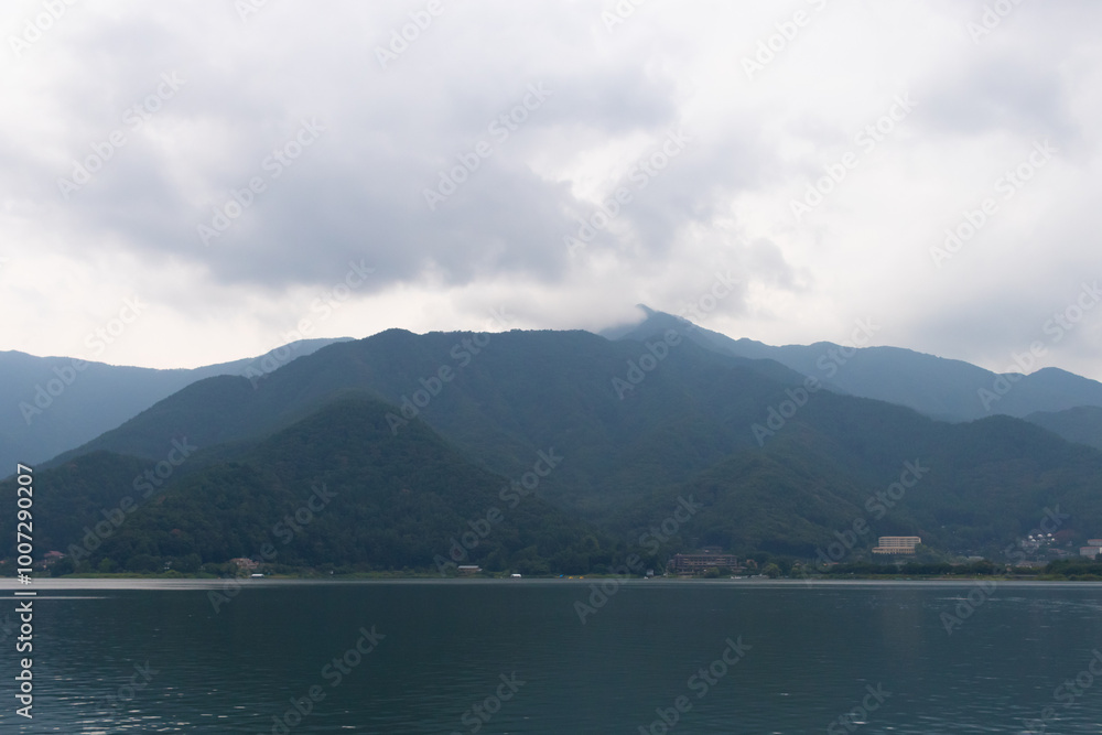 These are the rolling hills of Fujiyoshida, which is a small village nestled in Japan. The clouds look to be just floating past them. Lake Kawaguchi is shown below, which usually looks quite placid. These are the rolling hills of Fujiyoshida, which is a small village nestled in Japan. The clouds look to be just floating past them. Lake Kawaguchi is shown below, which usually looks quite placid.